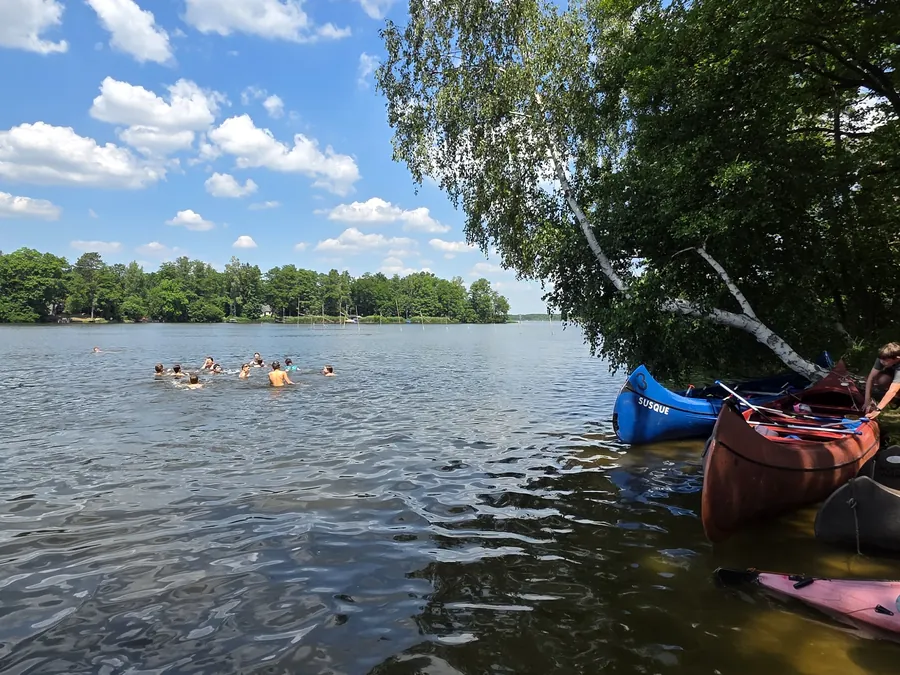 Weiter Blick über den See, Kanus am Ufer festgemacht