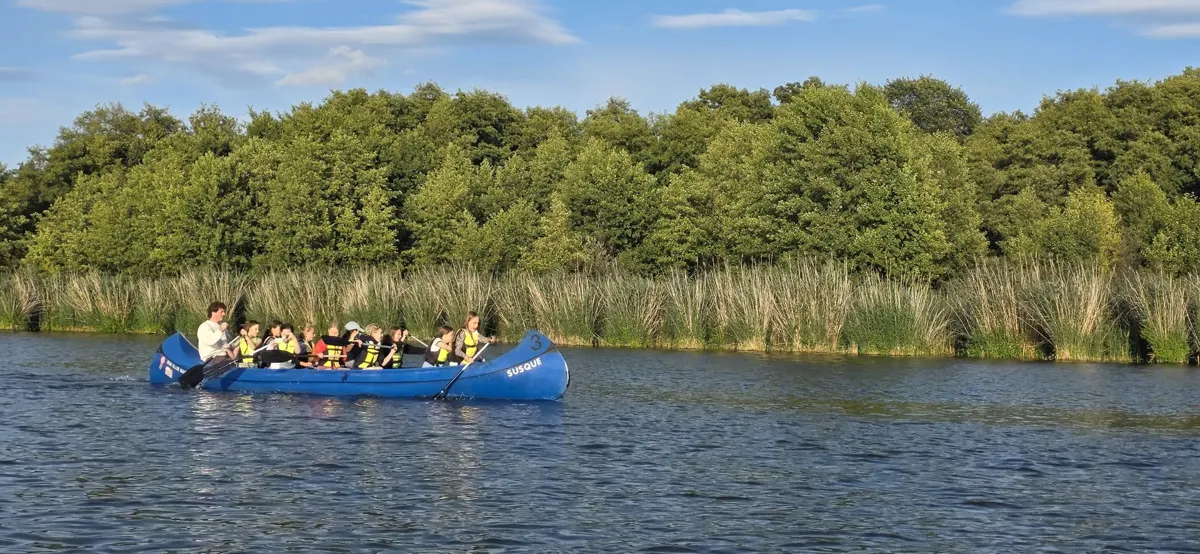 Voll besetzter Kanadier vor dem Schilf