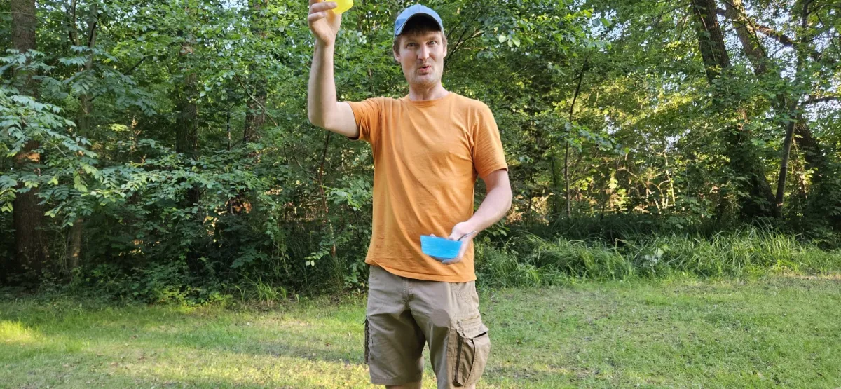 Christian Herold erklärt auf der Wiese am See ein Geländespiel